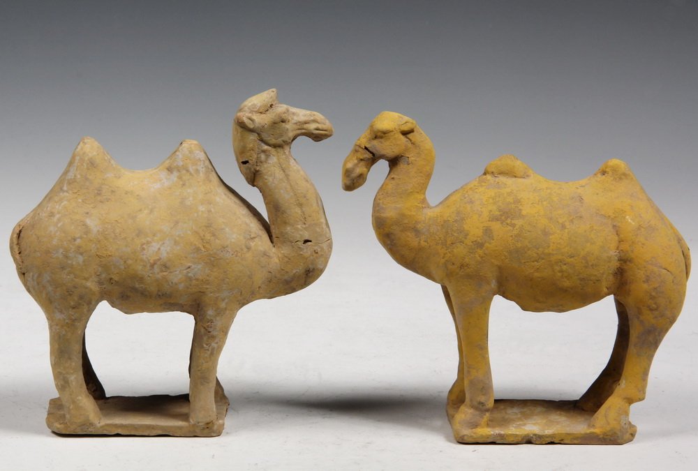 PAIR OF REPRODUCTION CHINESE HAN DYNASTY STYLE CAMELS -: PAIR OF REPRODUCTION CHINESE HAN DYNASTY STYLE CAMELS - This pair, perhaps examples of male and female Bactrian camels, native to Central Asia, are of molded and applied terra cotta construction and b