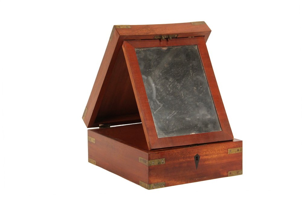 GENT'S TRAVEL SHAVING BOX - 19th c. British Brass Bound: GENT'S TRAVEL SHAVING BOX - 19th c. British Brass Bound Mahogany Case with fold-out framed mirror, lock with inlaid diamond escutcheon. 4 1/4" x 9" x 11". Loss to finish, one hinge loose, no key, shri