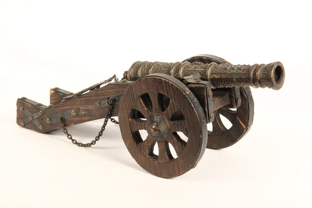SPANISH CANNON MODEL - Cast Brass, Tin and Wood Model: SPANISH CANNON MODEL - Cast Brass, Tin and Wood Model of an 18th c Field Artillery Piece, wooden wheels with black painted tin rims, brass tacking, shovel & pick, 5 1/2" x 14" x 5", good condition. A 