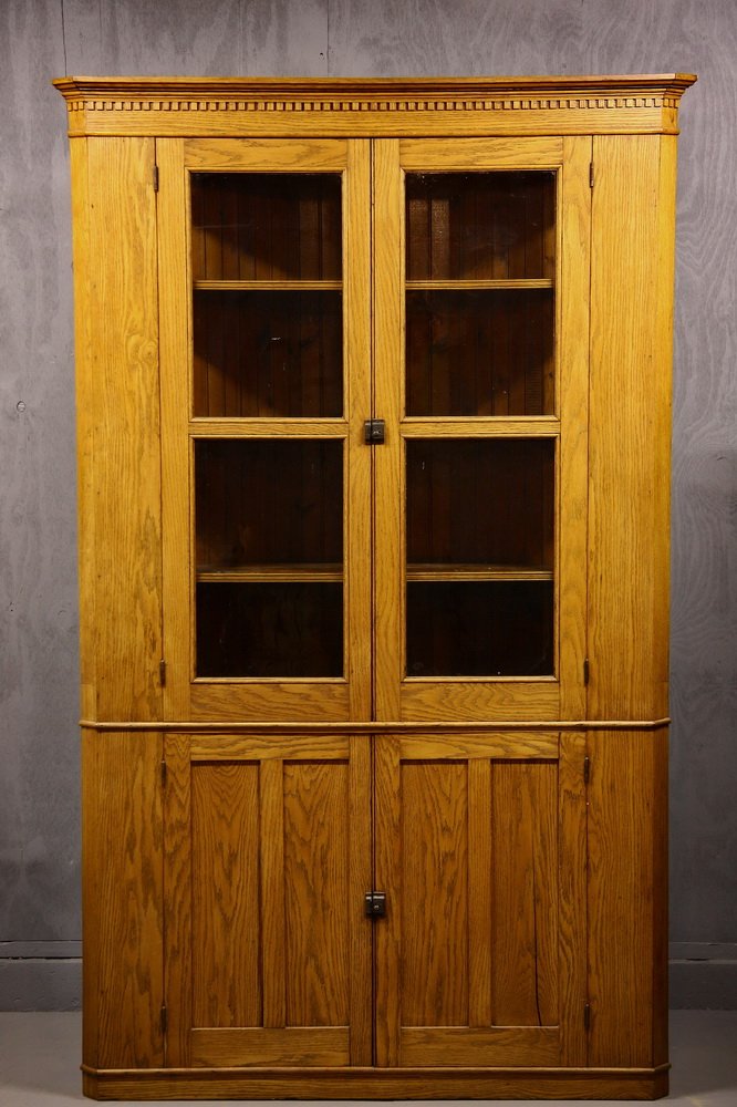 CORNER CUPBOARD - American Golden Oak Corner Cupboard,: CORNER CUPBOARD - American Golden Oak Corner Cupboard, circa 1910, the molded flat cornice with dentils, canted corners, two doors with two lights of old rippled glass set in half round molding, three