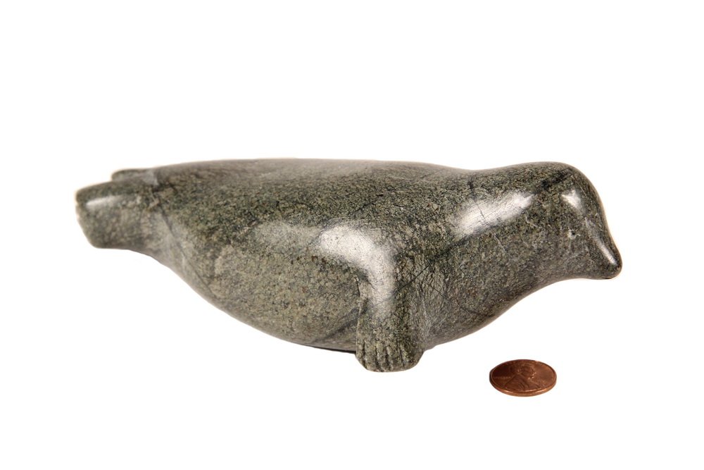 INUIT SOAPSTONE CARVING - Seal by Sarah Joe Qinuajua: INUIT SOAPSTONE CARVING - Seal by Sarah Joe Qinuajua (Puvernituq, 1917-1988), signed, 7 1/2" long. One small scuffed area on back.