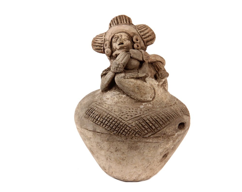 PRE-COLUMBIAN POTTERY - Mayan/Jaina Offeratory Closed: PRE-COLUMBIAN POTTERY - Mayan/Jaina Offeratory Closed Jug surmounted by a Falling Ball Player in ornate headdress, the sides of the jug with incised decoration, having a single vent hole. 5 1/2" tall.