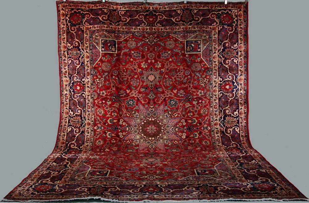 ISFAHAN CARPET - 9'7" x 12'9" - Central Persia, with: ISFAHAN CARPET - 9'7" x 12'9" - Central Persia, with rosette medallion surrounded by flowerheads and scrolling vines in ivory, slate blue, taupe, light blue and green on red field, blue flower and scr
