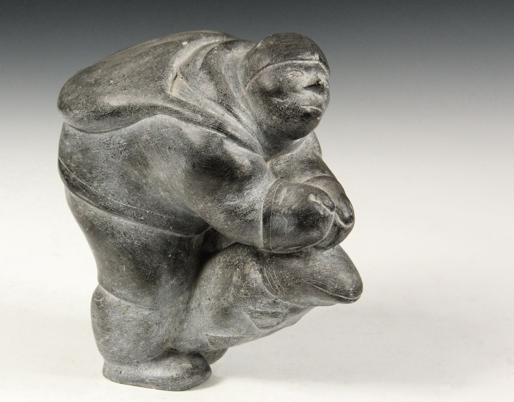 INUIT ESKIMO SCULPTURE - Greystone Figure of a Standing: INUIT ESKIMO SCULPTURE - Greystone Figure of a Standing Fisherman with a Huge Fish, signed "Jogo-Ha" (?), circa 1970, 7 1/4" tall. Minor scuffs.