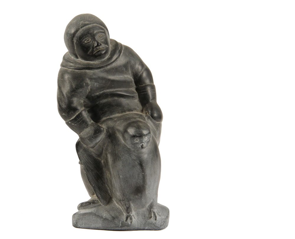 INUIT ESKIMO SCULPTURE - Greystone Figure of a Standing: INUIT ESKIMO SCULPTURE - Greystone Figure of a Standing Hunter in his Anorak, wrestling with a Penguin, signed illegibly, circa 1970, 10" tall. Minor scuffs.