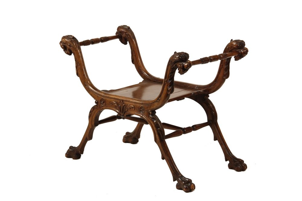 CURULE CHAIR - 19th c Renaissance Revival Court: CURULE CHAIR - 19th c Renaissance Revival Court (curule) or Savonarola Chair, in carved walnut, with lion head arms, lion paw feet, leaf and blossom carved frame, panel seat, 13 1/2" seat, 22 1/2" arm