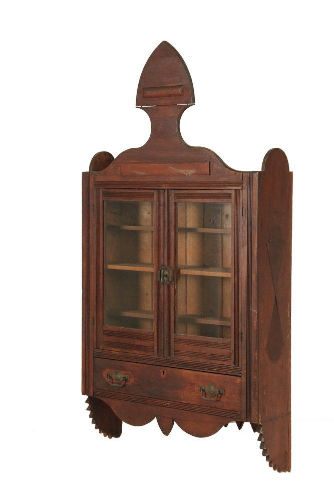 WALL CABINET - Eastlake Walnut Display Cabinet with: WALL CABINET - Eastlake Walnut Display Cabinet with flat spade form crest, two glass doors over four shelves, bead and board backing, reeded framing, fancy cast iron latch, single drawer below with ma