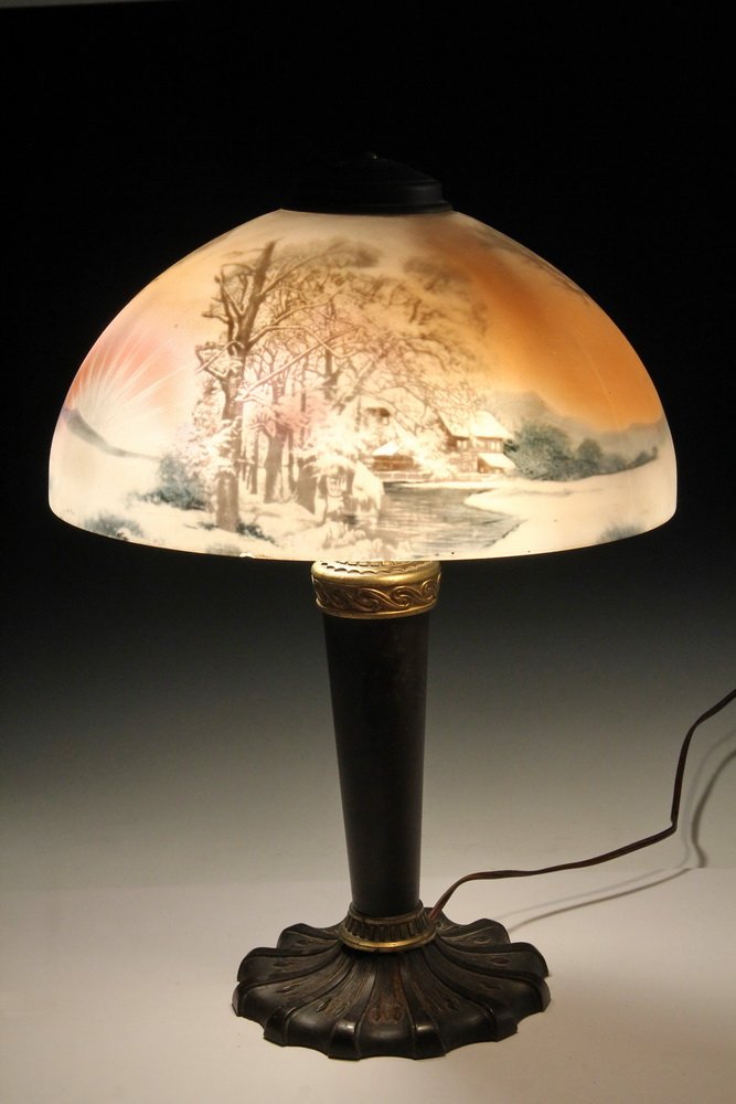 REVERSE PAINTED TABLE LAMP - Reverse Glass Pittsburgh: REVERSE PAINTED TABLE LAMP - Reverse Glass Pittsburgh Lamp with house scene, gilt and bronzed spelter base, two sockets with pull chains, original wiring is intact, 20" x 14 1/2" diam. One small rim f
