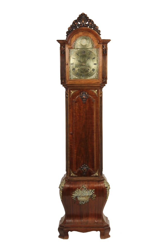 DUTCH STYLE TALL CLOCK - Three-Part Baroque Style Tall: DUTCH STYLE TALL CLOCK - Three-Part Baroque Style Tall Case Clock with English works, in a figural mahogany case, having a brass dial engraved "John Taylor, London", circa 1780, mounted into the bonne