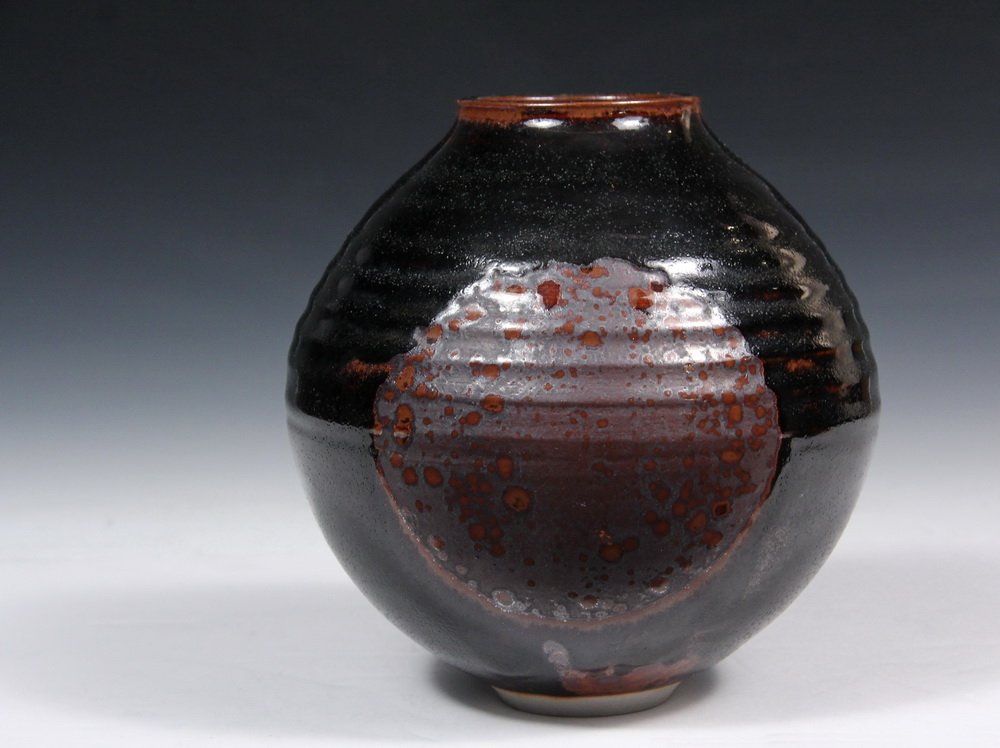 BROTHER THOMAS BEZANSON (VT, 1929-2007) - Early Temoku: BROTHER THOMAS BEZANSON (VT, 1929-2007) - Early Temoku Ovoid Vase with broad rimmed opening, in a dark brown glaze with speckled iron medallions having a lavender tint. Marked inside small foot "Bened