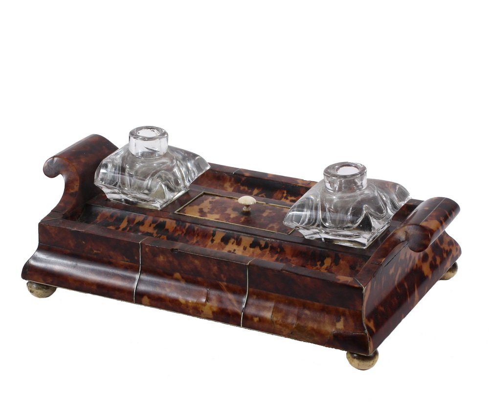 TORTOISESHELL DESK STAND - Early 19th c. English,: TORTOISESHELL DESK STAND - Early 19th c. English, having scrolled handles, integral pen trays, two glass ink bottles, covered central compartment, ogee sides, set on ball feet. 3 1/4" x 10 1/4" x 6 1/