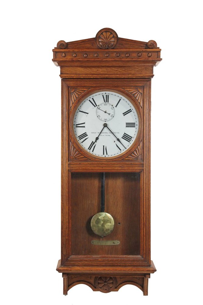 RAILROAD STATION REGULATOR CLOCK - Golden Oak Cased: RAILROAD STATION REGULATOR CLOCK - Golden Oak Cased Master Office Clock by the Self-Winding Clock Co. of New York, circa 1910, with the original pendulum and locking key, electrified with battery tray