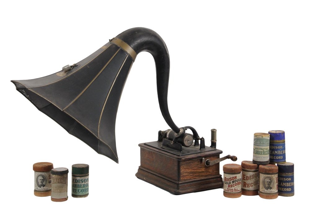 EDISON PHONOGRAPH - Model D Cylinder Phonograph with: EDISON PHONOGRAPH - Model D Cylinder Phonograph with oak case, serial number 707198, black and gold swan's neck tin horn, box of (10) extra cylinders, crank. Roughly 10" x 13" x 9" player, 23" x 18" x