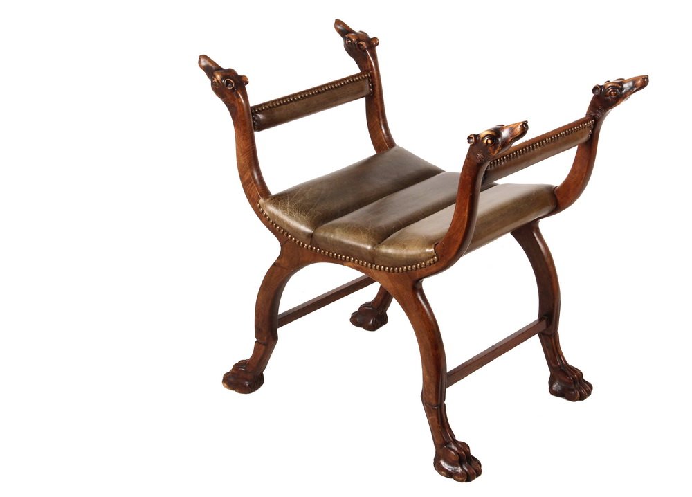 WINDOW BENCH - Curule Form Chair with Camel Head finial: WINDOW BENCH - Curule Form Chair with Camel Head finial carvings, resting on carved lion paw feet, upholstered in coffee brown channeled leather with brass tack edging, 16 1/2" seat, 27 1/2" arms, 29