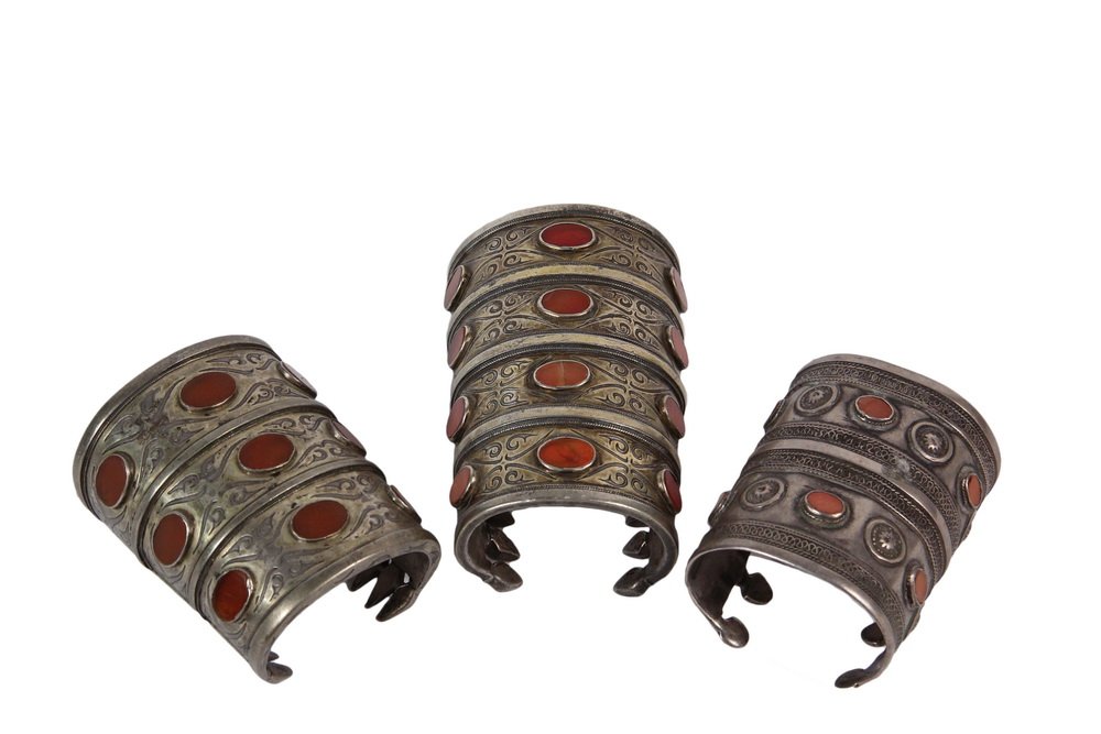 (3) SILVER AND AGATE BRACELETS - Turkoman Cuff: (3) SILVER AND AGATE BRACELETS - Turkoman Cuff Bracelets, late 19th to early 20th c., having engraved and wireworked ranks, with cabochon settings for the flat faced stones, serrated interior edges, 3