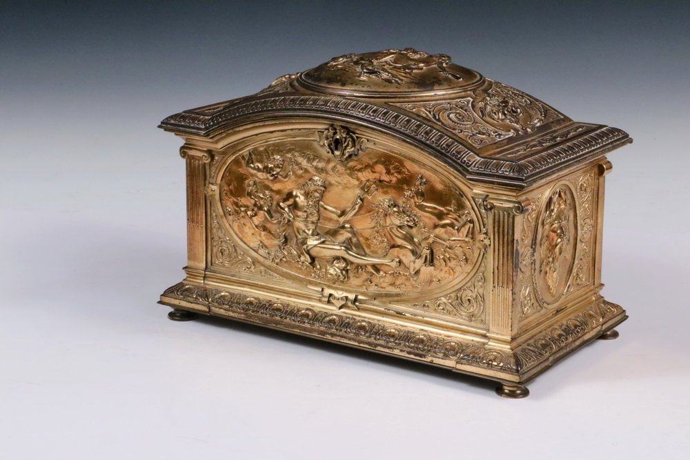 JEWELRY CASKET - Classical Revival Gilt Bronze Casket: JEWELRY CASKET - Classical Revival Gilt Bronze Casket with bas relief panels of Roman dieties, stepped and arched hinged top having a molded edge, reeded column corners, molded base with disc feet, th