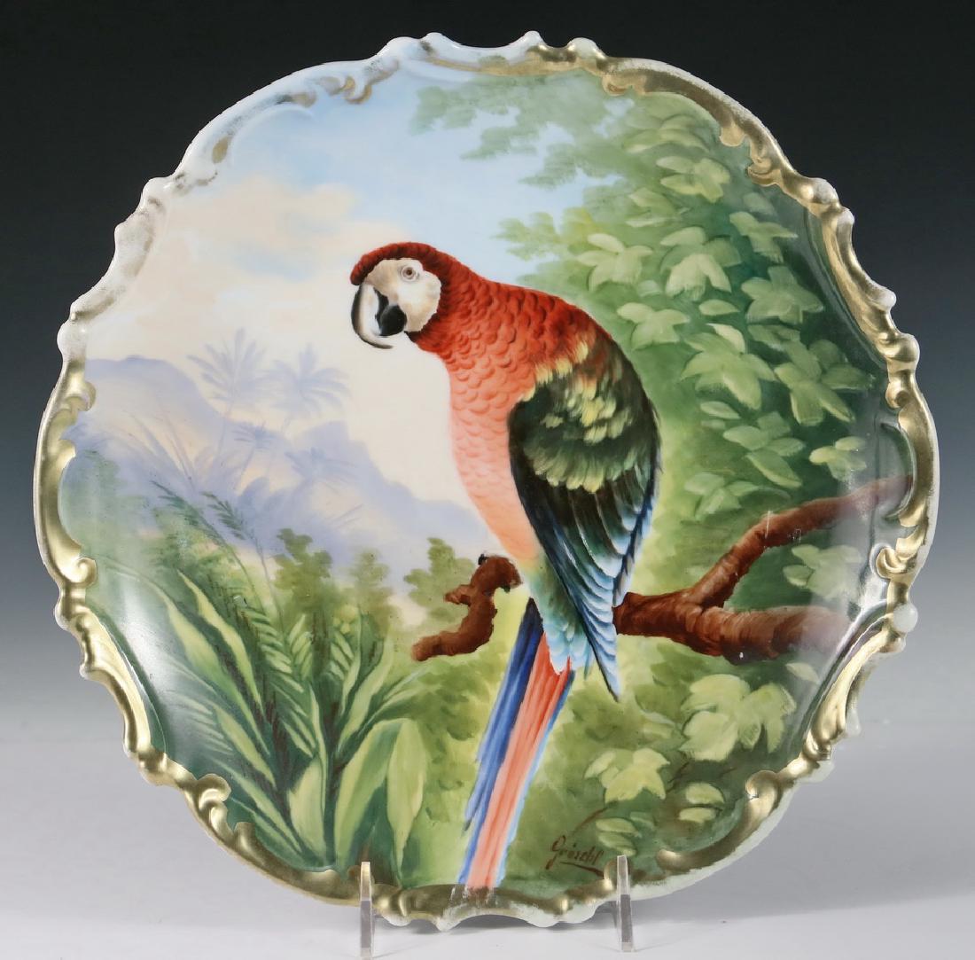 CHARGER: Lewis Straus & Sons Austrian Porcelain Charger, c. 1900-1910, with hand painted image of a parrot in tropical surroundings signed 'Groschl', gilt scalloped edge, blue 'L.S. & S. Austria' mark with bee