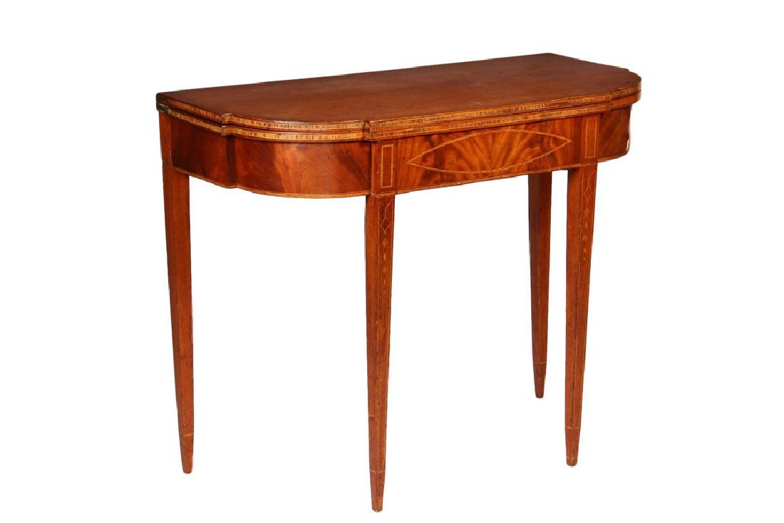CARD TABLE: Period Hepplewhite Card Table in mahogany with cross banded and string inlaid decoration, blocked and bowed top, conforming skirt with cartouches at center and at leg posts, bellflower inlaid tapered 
