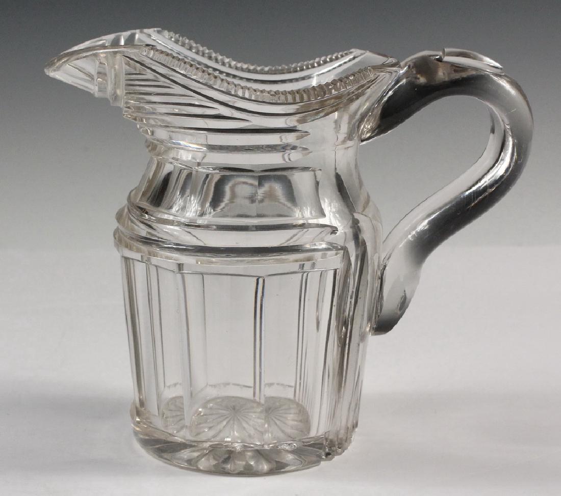 CUT GLASS WATER PITCHER: Heavy Bar Pitcher with deep cuts, bold handle, 7 1/2' tall. Some chips to edge of lower cut.