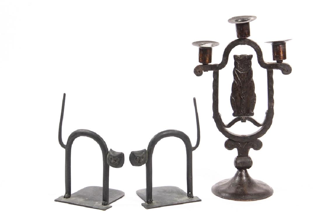ARTS & CRAFTS CANDELABRUM & LATER BOOKENDS: Cat Themed Single Wrought Iron Three-Stem Candelabrum in scumbled bronze paint, featuring a Seated Cat in a central medallion, set on a round base with scrollwork. Circa 1920. Roughly 13 1/2" x 7 1/2"