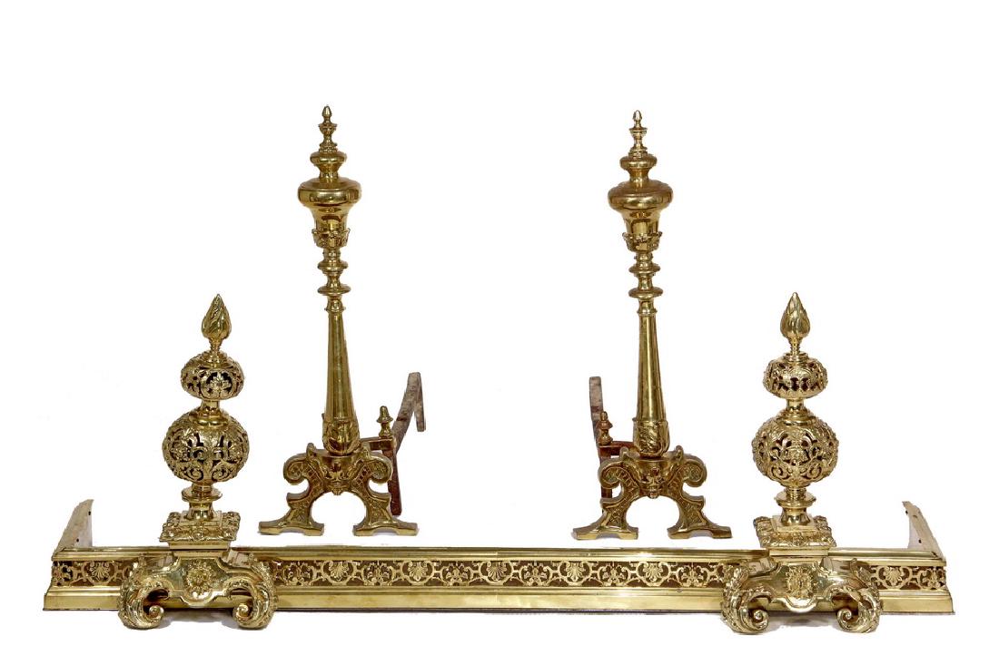 FANCY FIREPLACE FENDER & PAIR OF ANDIRONS: All late 19th c., heavy polished brass, probably English, but unmarked, including: Renaissance Revival Fender with built-in faux andirons, reticulated, with a flame finial, and a molded, reticulated g
