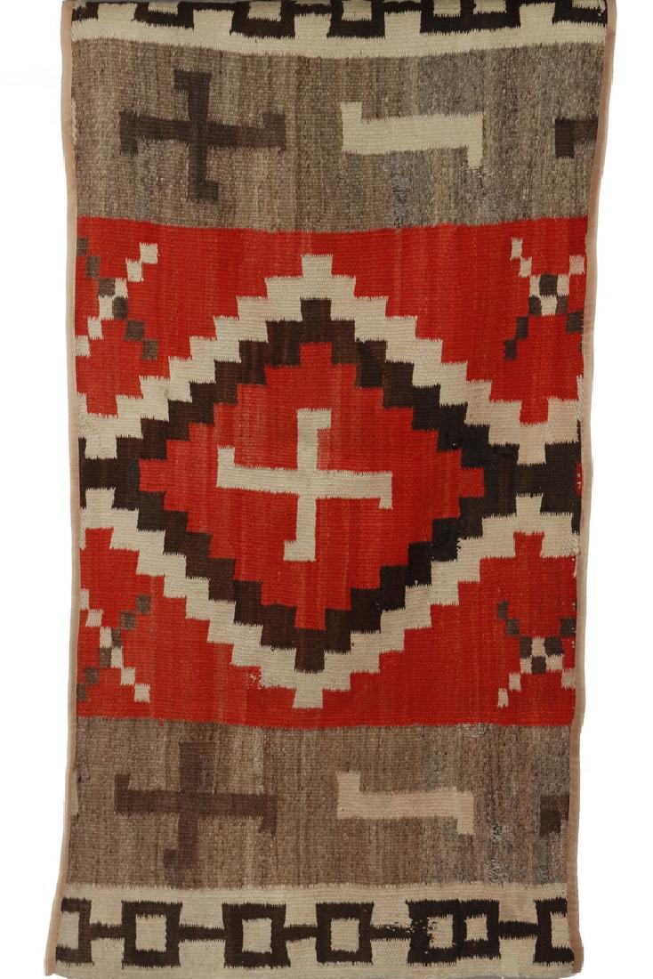 NATIVE AMERICAN WEAVING: 32" x 60 1/2" - Navajo Indian Rug, Ganando Red, with solar symbols, twirling logs, steppes and chain ends. Old repairs, cotton tape bound long edges.
