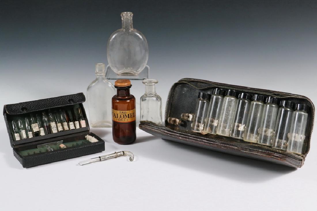 (2) PHARMACOLOGICAL KITS, (4) BOTTLES & SILKS: Two Black Leather Clamshell Cases, one with large bottles having screw top lids, the other with snap-top pipetted in fitted interior; PLUS Three Early Clear Glass Medicine Bottles; PLUS Brown Bottle w