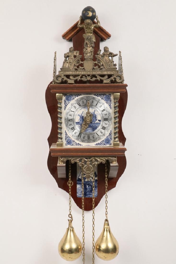 WAG-ON-THE-WALL CLOCK: Replica Dutch Wag-on-the-Wall 8-Day Clock, with Delft tile face and Atlas holding a globe, brass gallery with figures and "Nu elck syn sin" around top, weight driven movement made in 1983 by Franz Her