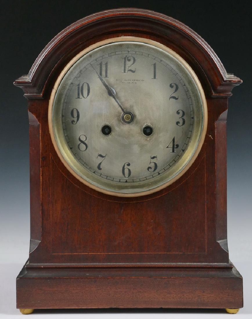 MANTEL CLOCK: Mahogany String Inlaid Arch Top Clock made for Bailey, Banks & Biddle Co. of Philadelphia, by Japy Freres of France, with brass time and chime works, silver plated dial, 12" x 9" x 5". Good condition.