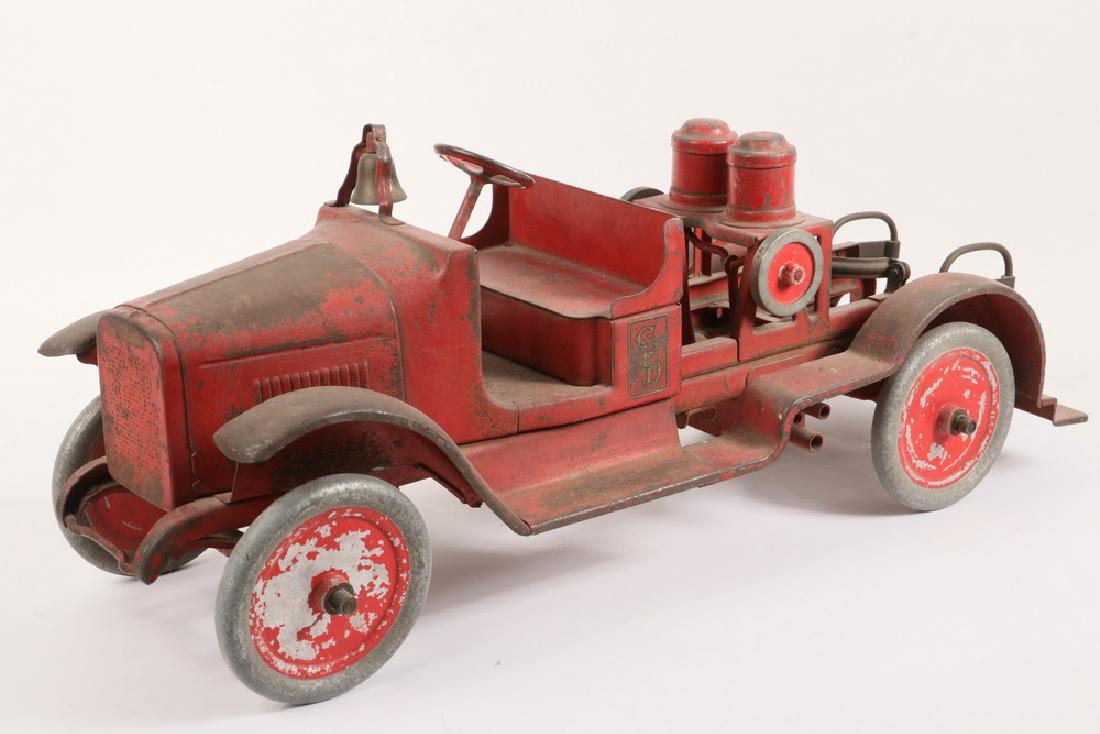 BUDDY L TOY FIRE ENGINE: Circa 1925, open front cab with brass bell on cowling, fire pumper body, missing the nickel plated boiler. 10" x 23" x 9". About 50% paint.