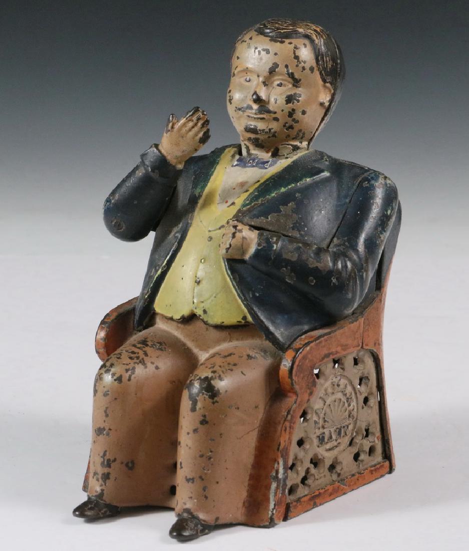 MECHANICAL BANK: Painted Cast Iron Tammany Hall Mechanical Bank by J & E Stevens, 19th c., depicting a seated Boss Tweed, place a coin in his hand and he deposits it in a slot above his left arm, 'Tammany Bank' impres