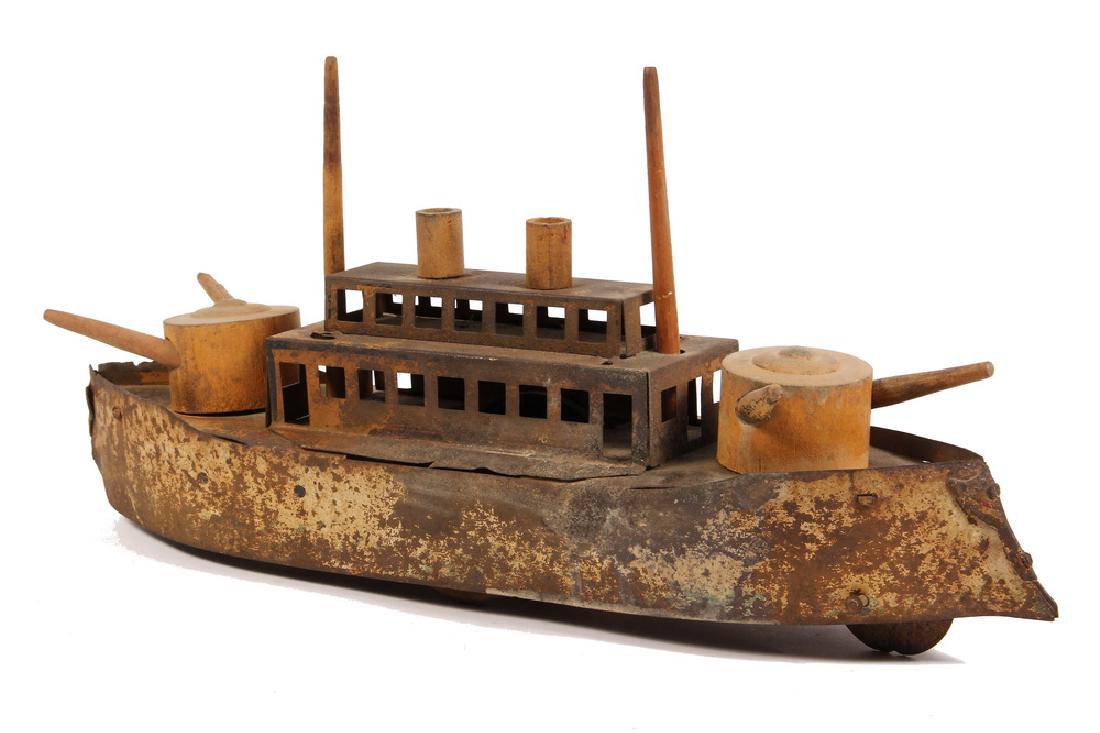 TIN BATTLESHIP: American Dreadnought by Dayton Toy Company, in painted tin with wooden turrets, guns, masts & stacks. Metal wheels with counterweight drive. Circa 1905.