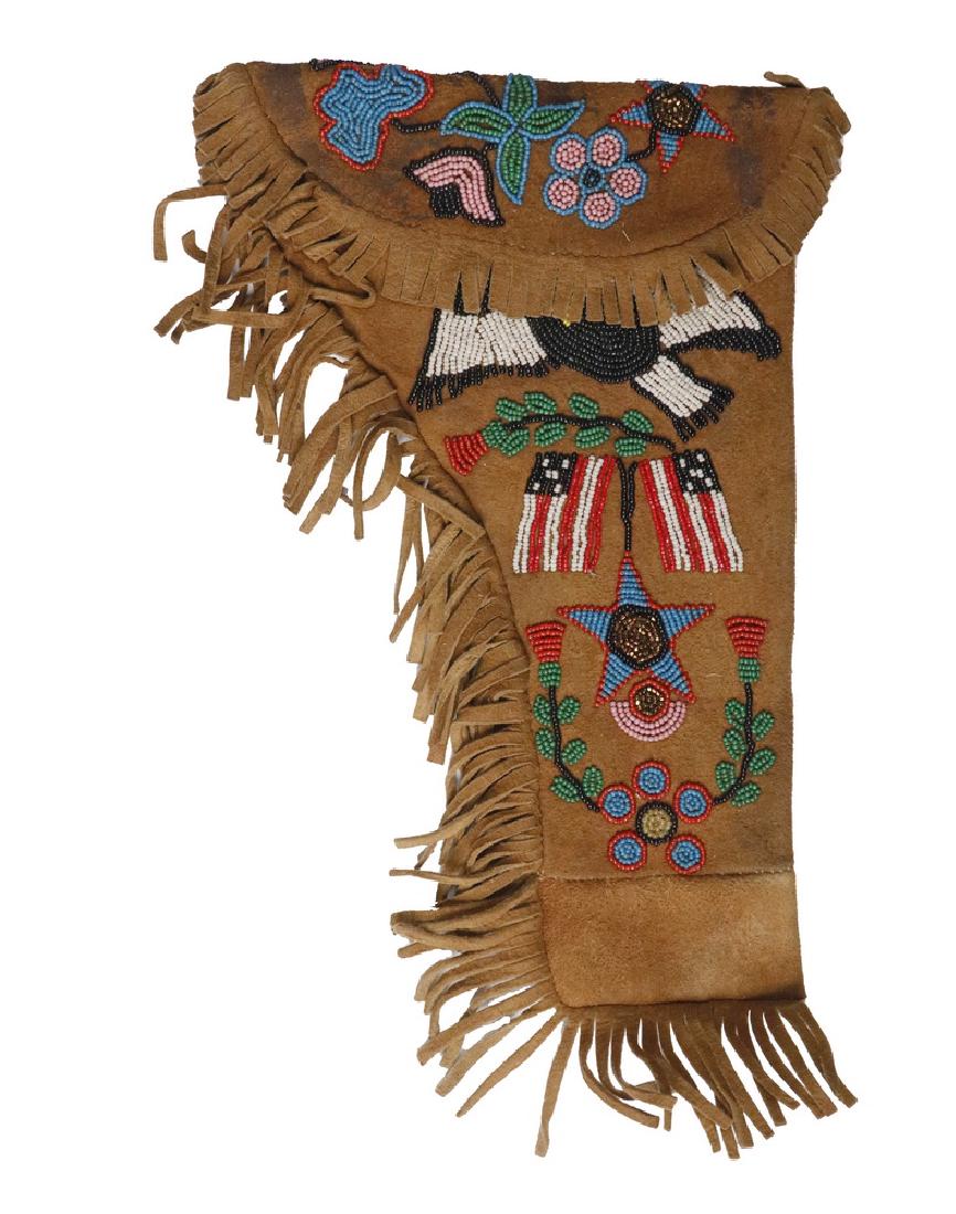 NATIVE AMERICAN HOLSTER: Late 19th to early 20th c. Plains Indian Buckskin Fringed Holster with beaded decoration of the American Eagle, two US Flags, a star with copper center and typical floral designs. 12" x 8". Repaired f
