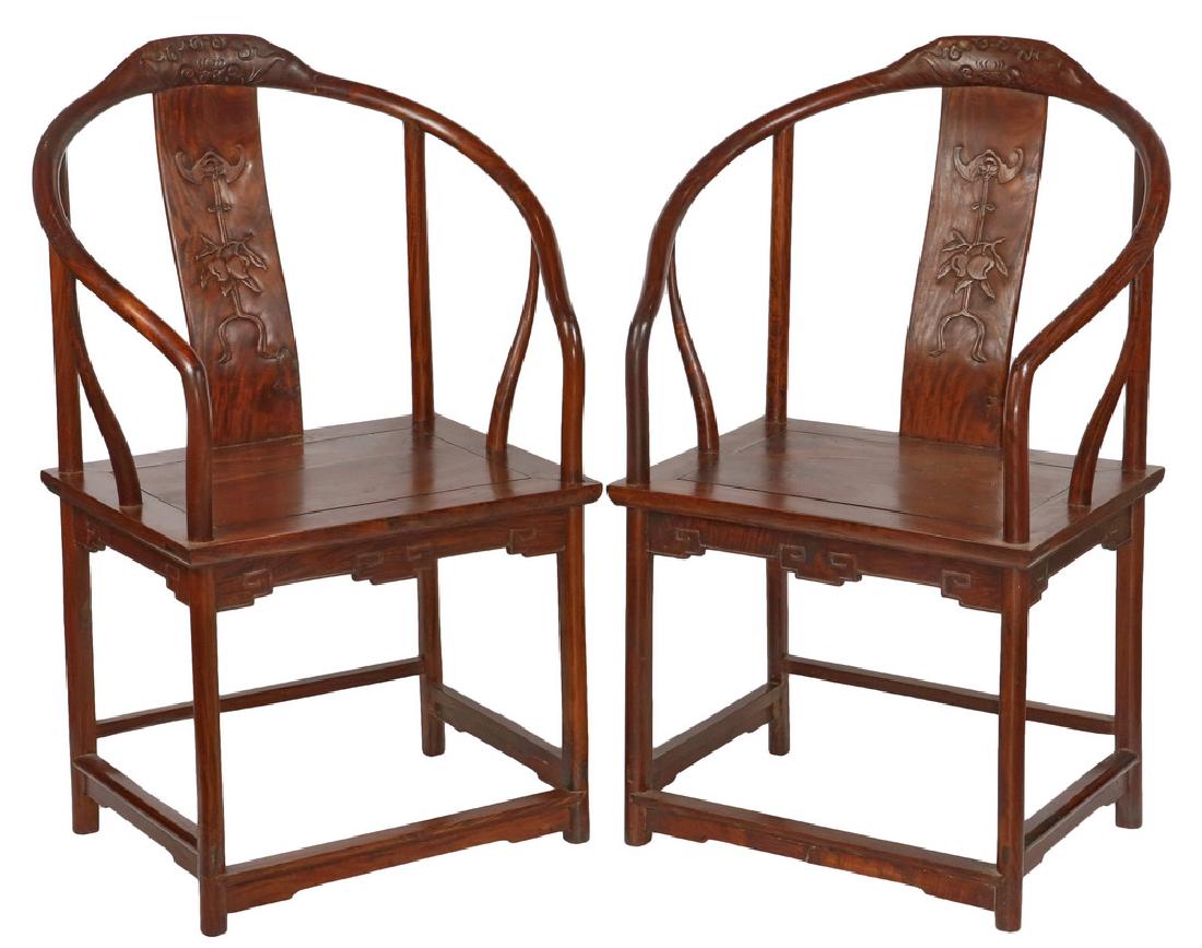 PAIR OF CHINESE ARMCHAIRS: 19th c. Huanghuali Wood Ming Style Ancestral Thrones, having a continuous hoop arm, tao tie carved crest, S-curved splat featuring symbols of fortune, a bat with branch of plums suspended from a ribbo