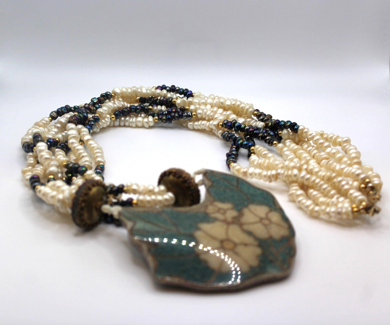 Large 4 strands of white and peacock fresh water pearls and wood inlay: Very pretty Large 4 strands of white and peacock fresh water pearls and wood inlay with flower and leaves designDesigner/Brand: UnknownMetal Purity: brassMetal: brassStone: white and peacock fresh wat