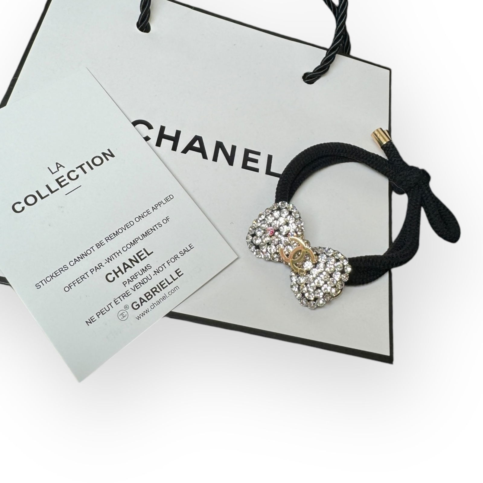 CHANEL White Rhinestone Gold CC Hair Bow Shaped L.A Collection Hair Tie: • CHANEL• Gabrielle• Hair Tie• White Rhinestone Covered • Hair Bow Shaped• Gold CC Logo• L.A Collection• Unopened/In Original Packaging • CHANEL Gift Bag I