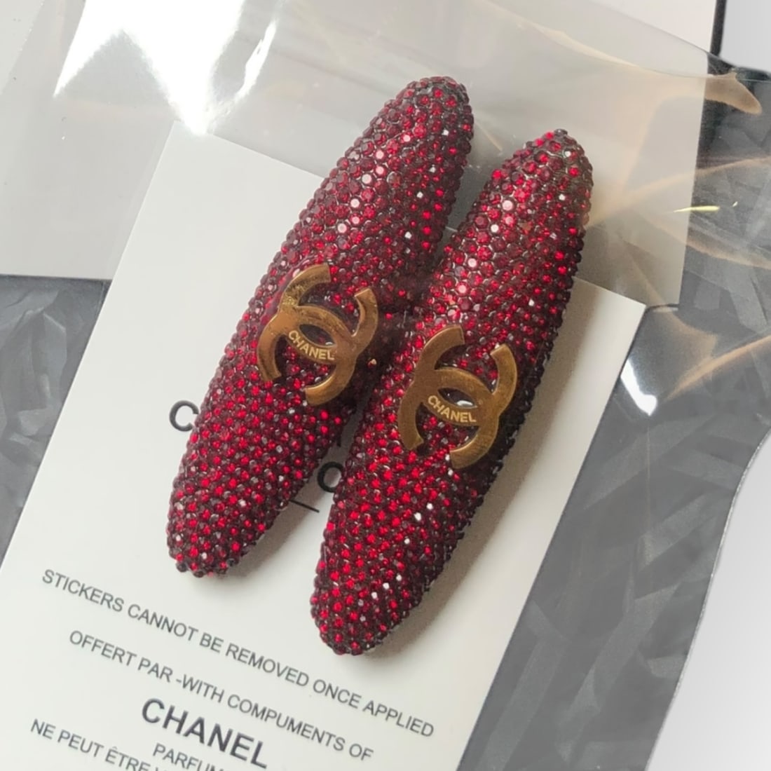 CHANEL 2Pc Red Rhinestone/Gold CC Long Oval L.A Collection Hair Clips: • CHANEL • Gabrielle • 2Pc Set • Hair Clips • Red Rhinestone • Gold CC Logo • Black Tone Hardware • Long Oval Shaped • L.A Collection • Unopened/In Or