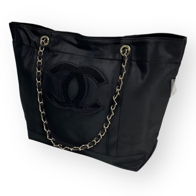 CHANEL Black On Black/Silver Sequin Logo Beaute Tote: • CHANEL • Tote • Black On Black • Silver Tone Hardware • Front Sequin CC Logo • Intertwined Leather Chain Strap • Shoulder Or Arm Carry • 16" x 12" x 5.1" (in)