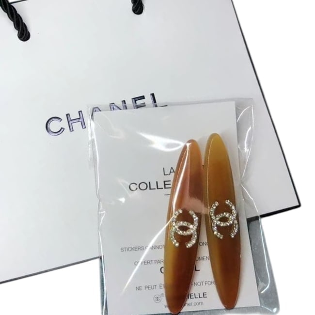 CHANEL2Pc Set Brown/Rhinestone CC Long Oval L.A. Collection Hair Clips: • CHANEL • L.A. Collection • Gabrielle • 2Pc Set • Hair Clips • Transparent Brown • White Rhinestone CC Logo • Gold Tone Hardware • Shape: Long Oval •
