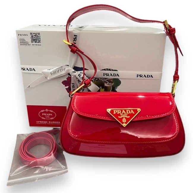 Prada Red Front Logo Beaute Bag & Original Box: • Prada • Cherry Red • Gold Tone Hardware • Signature Front Logo • Removable/Adjustable Strap Included • Single Strap • Shoulder Carry • Patent Pattern • M