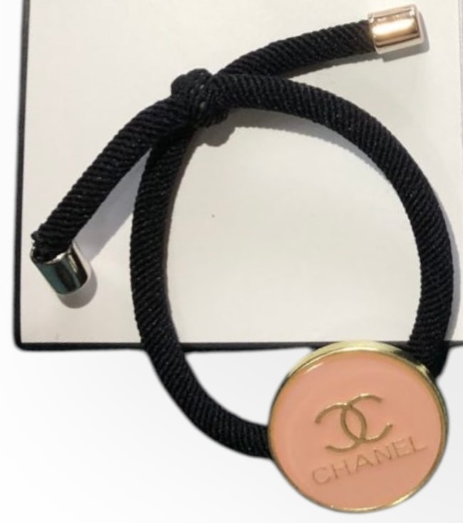 CHANEL Coral Pink/Gold CC Logo Round L.A Collection Hair Tie: • CHANEL • Gabrielle • Hair Tie • Coral Pink • Gold Trim • Shape: Round • Tie: Black • Front Logo • L.A Collection • Original CHANEL Gift Bag Included