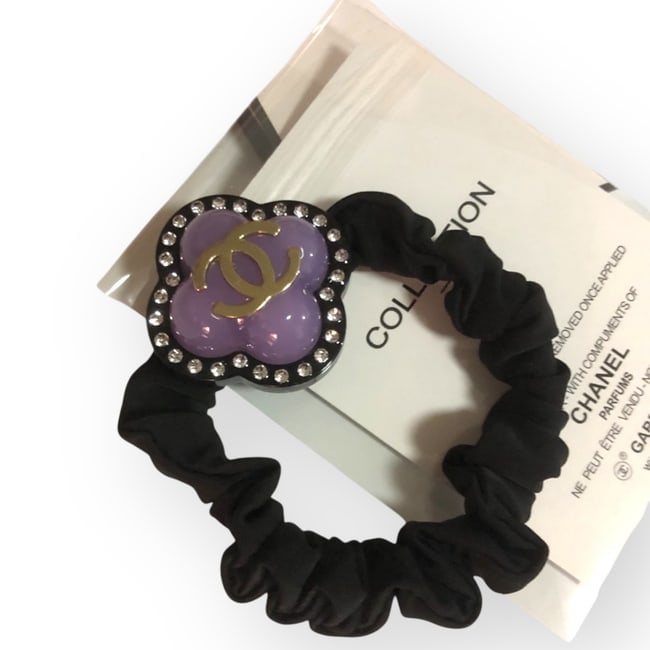 CHANEL Purple & Black Clove Hair Tie/Scrunchy & Gift Bag: • CHANEL • Transparent Purple • Black Tone Hardware • L.A Collection • Hair Tie/Scrunchy • Clover Shaped • White Rhinestone Trim • Front CC/CHANEL Logo • U