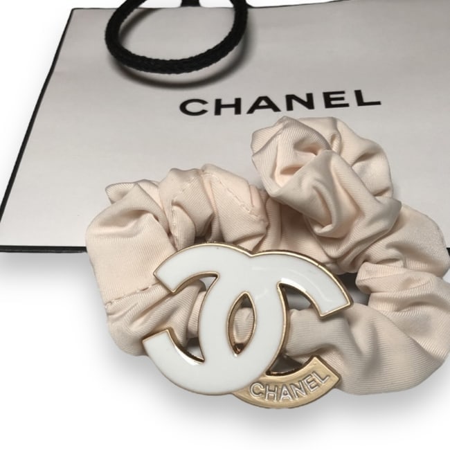 CHANEL Baby Pink White & Gold CC Hair Tie/Scrunchy & Gift Bag: • CHANEL • Light Pink • Shape: CC Logo • L.A Collection • Hair Tie/Scrunchy • Gold Accented CC Logo • White CHANEL Logo • Unopened/In Original Packaging •