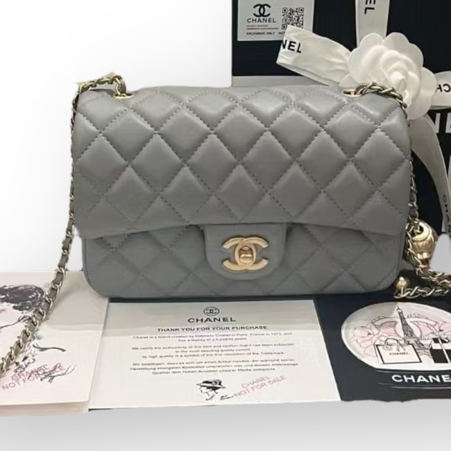 CHANEL Dark Grey Pearl Crush Mini Flap Beaute Bag & Original Box: • CHANEL • Dark Grey • Pearl Crush Mini Flap Bag • Decorative Charm Strap • Quilted Pattern • Gold Tone Hardware • 8” x 5” (in) • Original Box & Dus
