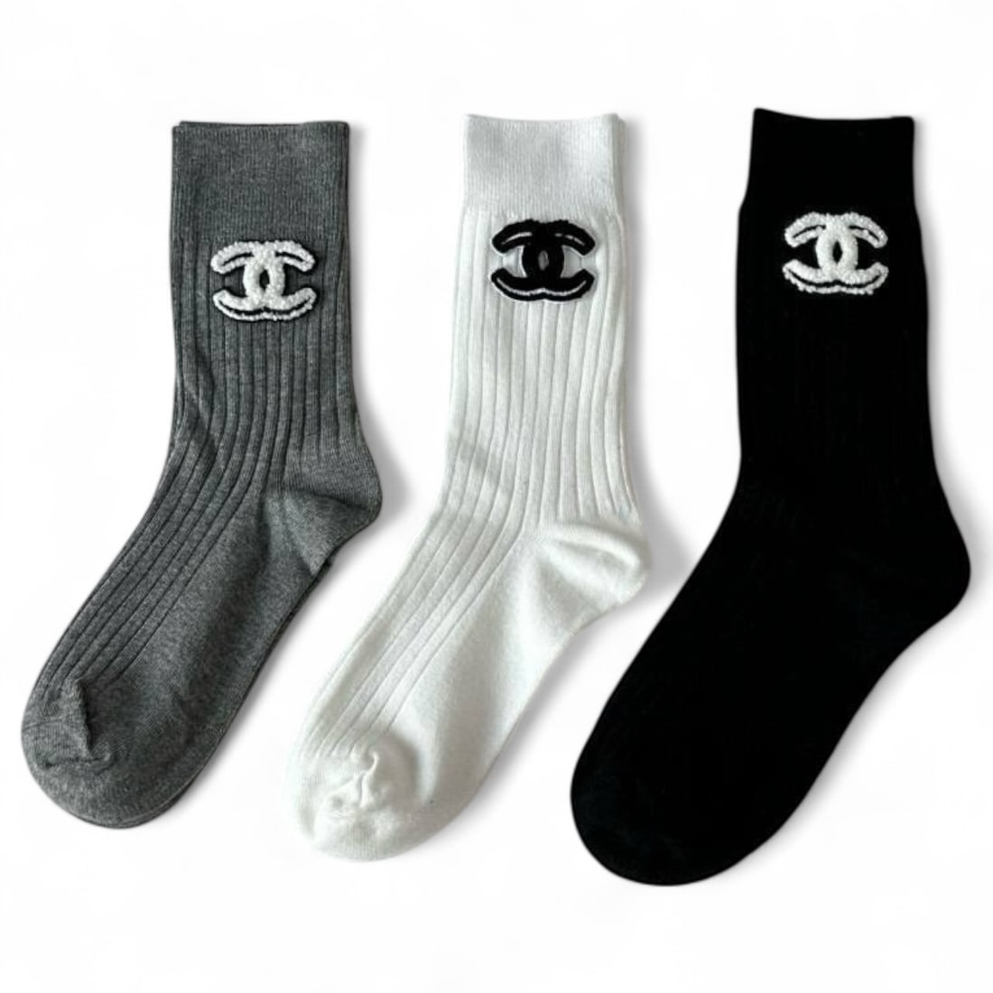 CHANEL 3Pc Signature White, Grey, & Black Trio Beaute Sock Set: • Indulge in luxury with this exquisite set of Chanel socks, combining luxury and comfort these are perfect for adding a touch of style to any wardrobe. • Included Colors: - Black - White -