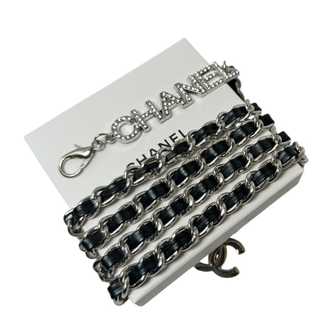 CHANEL Adjustable Black & Silver/Rhinestone Covered Logo Beaute Belt & Gift Bag: • CHANEL • Type: Belt • Collection: L.A. Collection • Strap Material: Intertwined Leather • Hardware: Silver Tone • Adjustable Length: 40" (In) • Feature: White Rhin