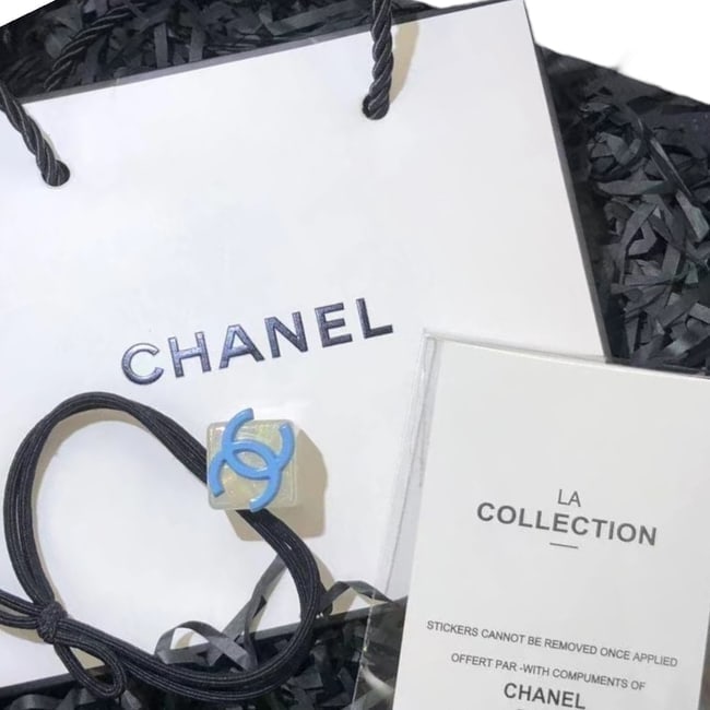 CHANEL Clear/Blue Cube CC Logo Hair Tie & Original Gift Bag: • CHANEL • L.A. Collection • Gabrielle • Hair Tie • Clear • Blue CC Logo • Tie Color: Black • Shape: Cube • Unopened/In Original Packaging &bu