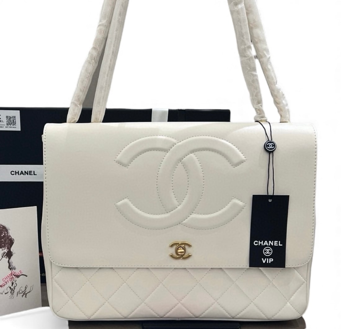CHANEL LG Quilted Pharrel White/Gold Beaute Bag& Original Box: • CHANEL • White • Quilted Pattern • Gold Tone Hardware • Front CC Logo • Signature CC Twist Lock Closure • Interior Zip Pocket • Intertwined Leather Chain Stra