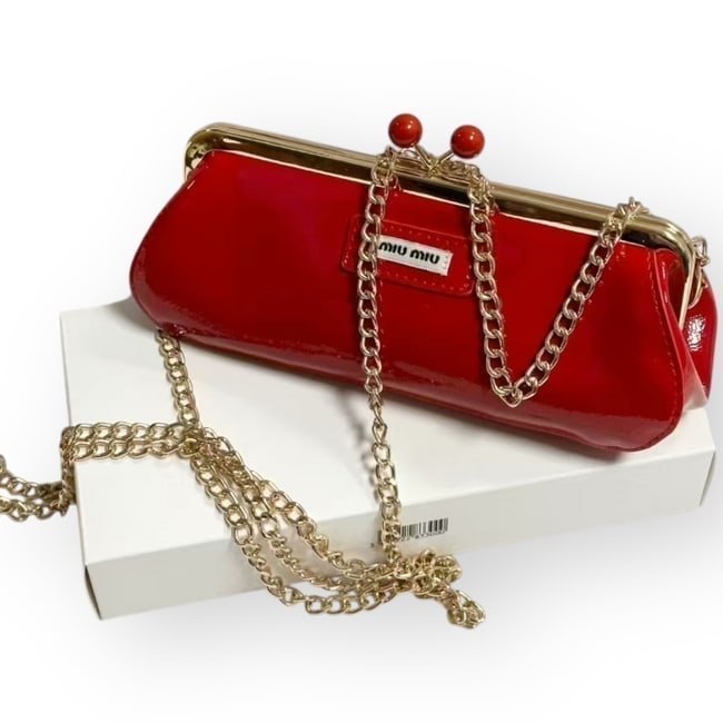Miu Miu Red & Gold Kiss Lock Beaute Clutch: • Miu Miu • Clutch • Red • Gold Tone Hardware • Patent Pattern • Kiss Lock Open/Closure • 8" x 3.5" (in) • Notice: The Thick White Paper Wrapped Around The Item