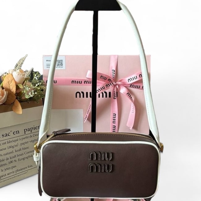 Miu Miu Brown/White Front Logo Rectsngle Beaute Bag & Gift bag: • Miu Miu • Handbag • Brown • White Accents • Front Logo • Zip Closure • Gold Tone Hardware • Adjustable Straps • Removable Straps • Original Box Incl